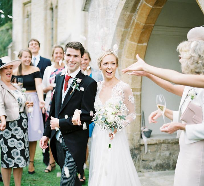 Confetti Exit | Bride in Suzanne Neville Camelia Gown | Groom in Traditional Tails | A Romantic Pastel Wedding at Dauntsey Park in the Wiltshire English Countryside | Imogen Xiana Photography