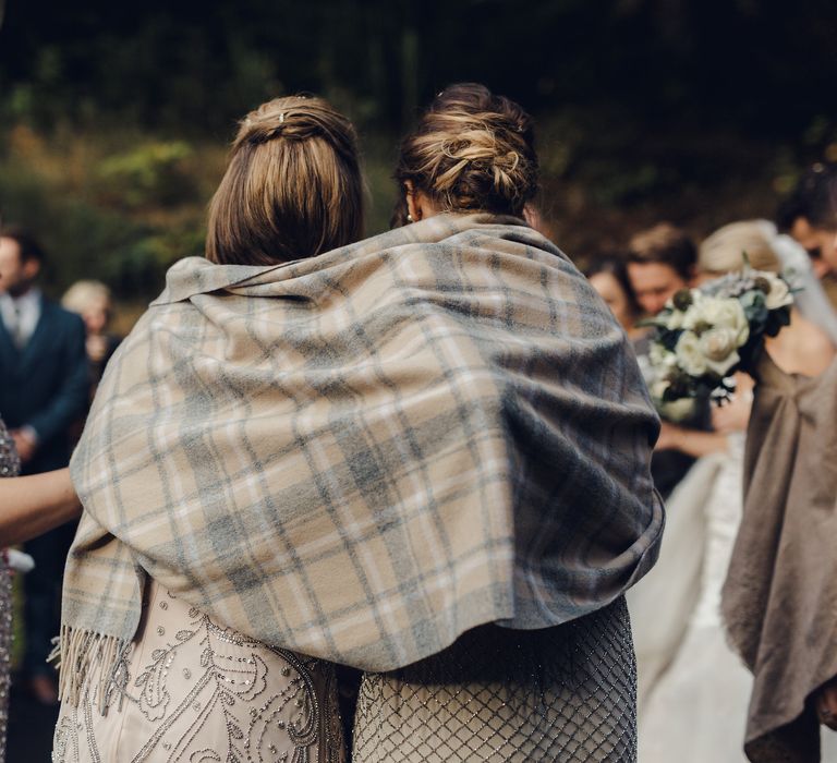 Bridesmaids Keep Warm Under Blanket