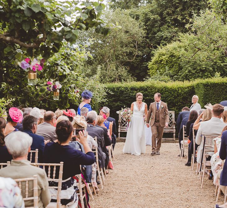 Outdoor Ceremony at Sulgrave Manor Northamptonshire | Bride in Charlie Brear Wedding Dress | Groom in Brown check Wool Suit | Nicola Casey Photography