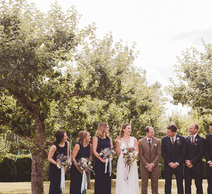 Wedding Party | Bride in Charlie Brear Gown | Bridesmaids in Navy Phase Eight Dresses | Groom in Brown Tweed Suit | Groomsmen in Navy Suits | Outdoor Ceremony at Sulgrave Manor Northamptonshire | Nicola Casey Photography