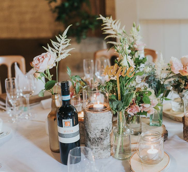 Tree Stumps, Candles & Flower Stems in Gold Spray Painted Bottles | Table Decor | Centrepiece | Pink & Gold Summer Wedding at East Riddlesden Hall Barn, Wiltshire | Laura Calderwoods Photography