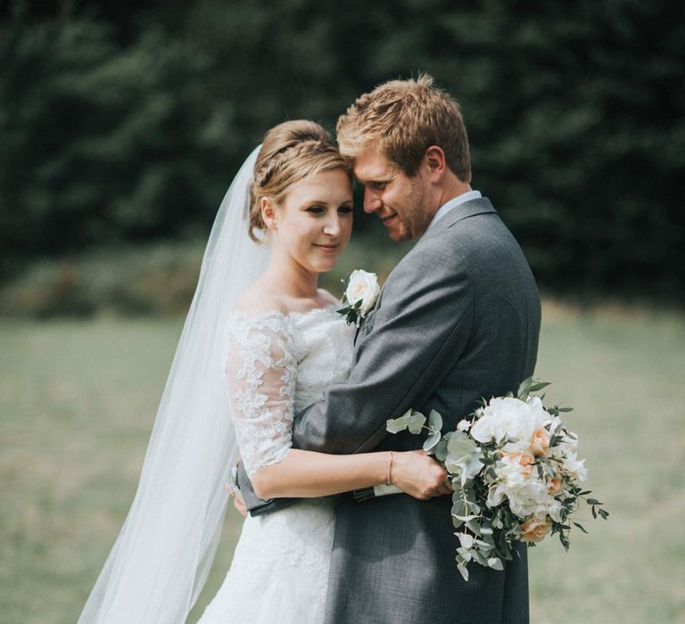 Bride in Pronovias White One Wedding Dress & Groom in Grey Morning Suit