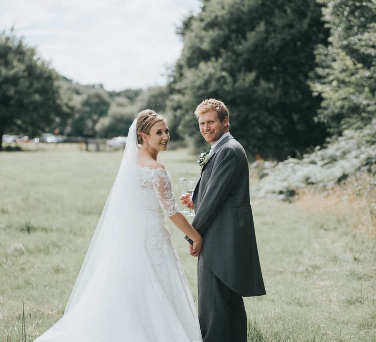 Bride in Pronovias White One Wedding Dress & Groom in Grey Morning Suit