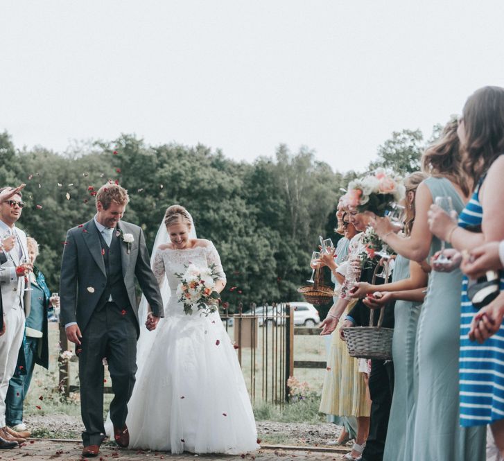 Confetti Moment with Bride in Pronovias White One Wedding Dress & Groom in Grey Morning Suit