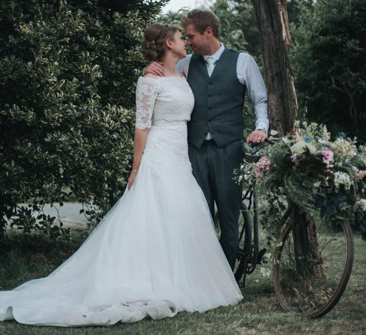 Flower Adorned Vintage Bicycle with Bride in Pronovias White One Wedding Dress & Groom in Grey Morning Suit