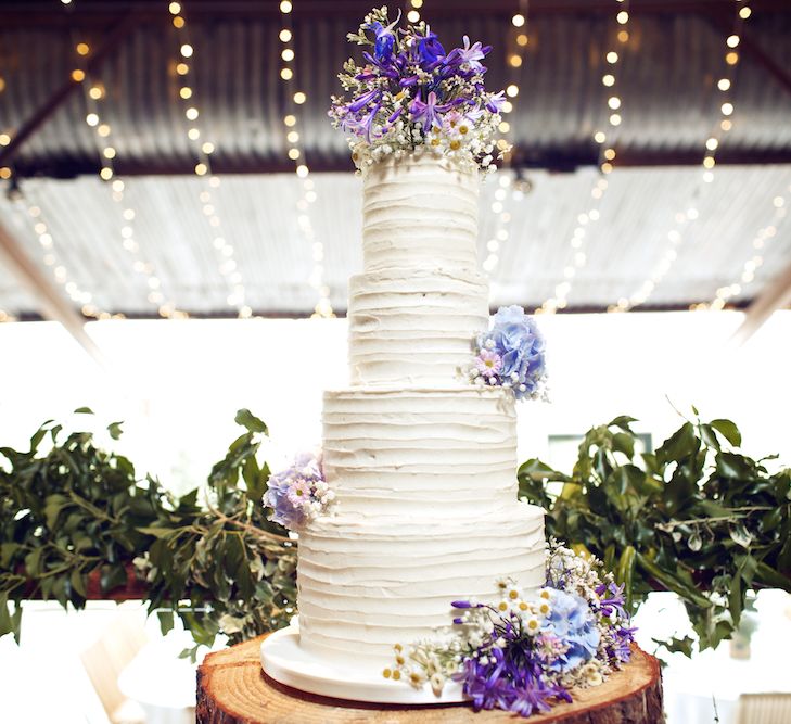 White Buttercream Wedding Cake With Purple Flowers