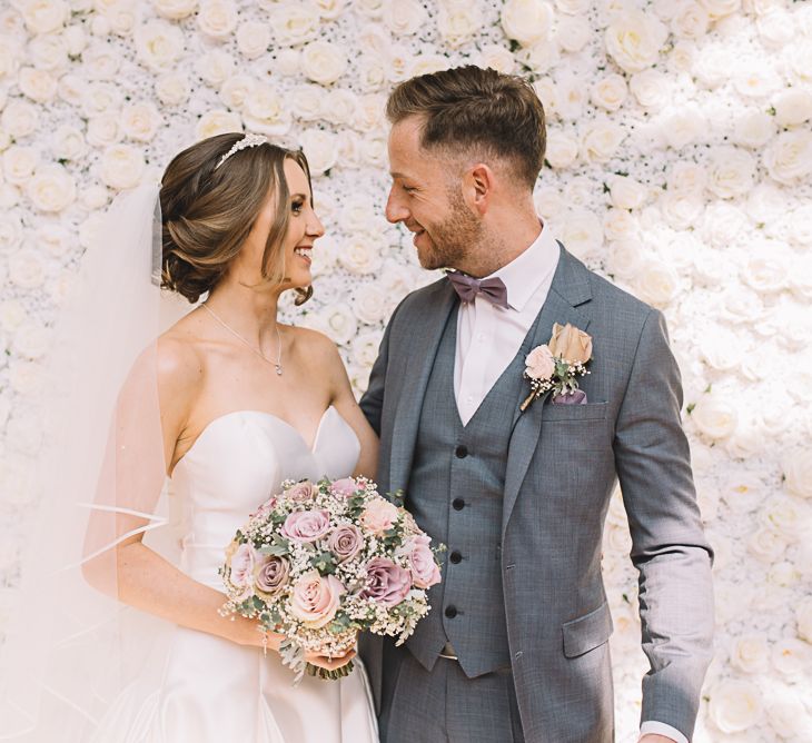 Flower Wall | Bride in Ronald Joyce Wedding Dress | Groom in Grey Moss Bros Suit | The Orangery Maidstone | Lucie Watson Photography | TDH Media Films