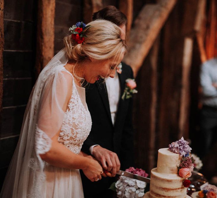 Bride & Groom Cutting the Cake | Colourful DIY Barn Wedding at The Manor Barn, Cambridge | Meghan Lorna Photography