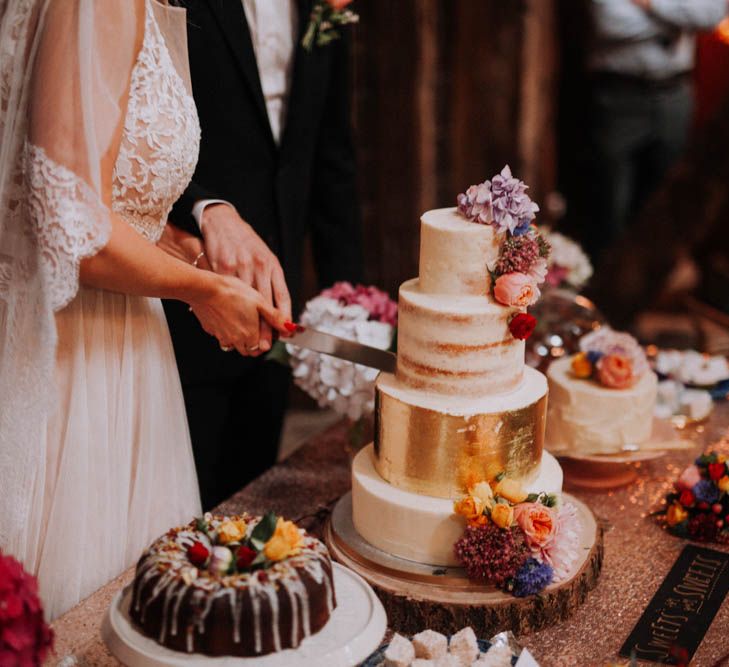 Bride & Groom Cutting the Cake | Colourful DIY Barn Wedding at The Manor Barn, Cambridge | Meghan Lorna Photography