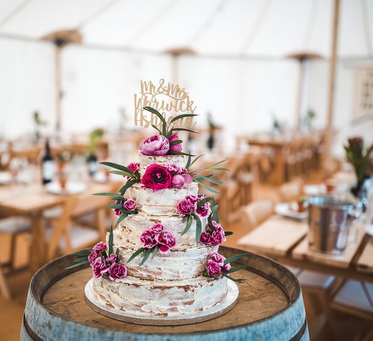 Semi Naked Wedding Cake on a Barrel with Flower Decor | PapaKåta Sperry Tent at Chafford Park in Kent Countryside | Eve Dunlop Photography | Roost Film Co.