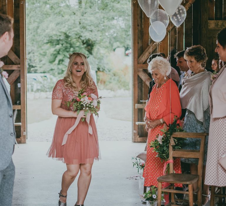 Wedding Ceremony | Bridesmaid Entrance | Coral Wedding Cake with Peony Decor | Bride in Anna Campbell Gown from Coco & Kate Boutique | Groom in Next Wool Suit | Rustic Barn Pink Summer Wedding at Nancarrow Farm in Cornwall | Ross Talling Photography