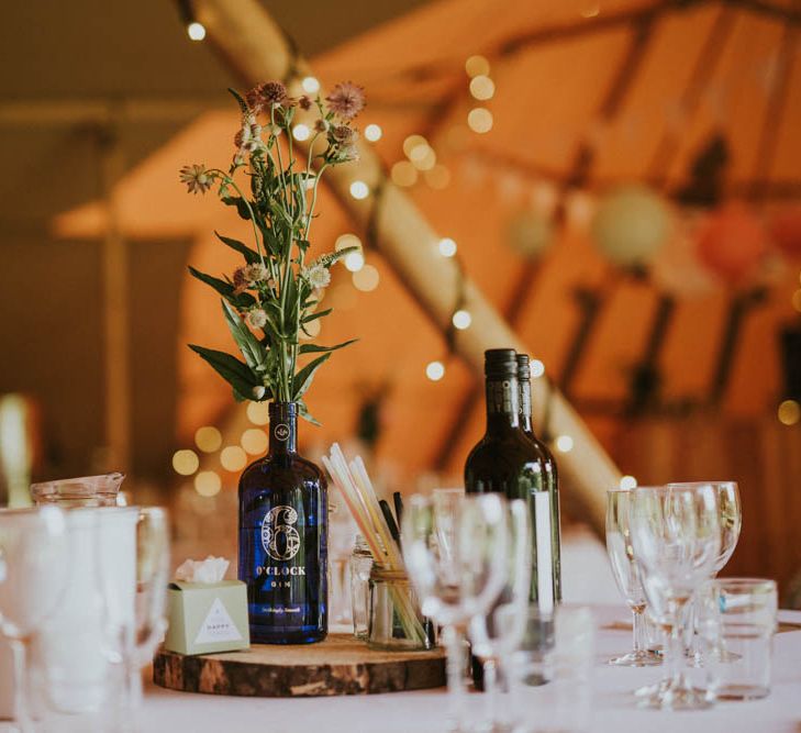 Tree Slice & Bottle Centrepiece | Rustic Tipi Wedding at The Grange, Belluton, Pensford | Images by Felix Russell-Saw & Ryan Winterbotham