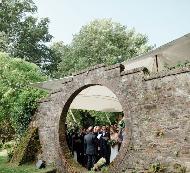 Outdoor Ceremony at Drenagh Estate in Northern Ireland | Bride in Bespoke Suzanne Neville Scarlett Bridal Gown | Protea Bouquet & Flower Crown | The Lou's Photography