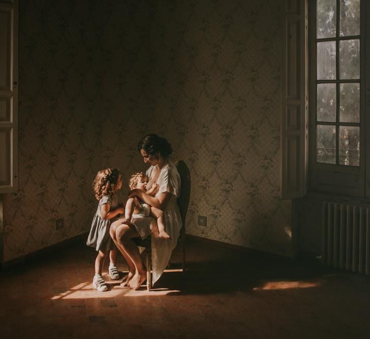 Bride Feeding Her Baby Girl On Wedding Morning