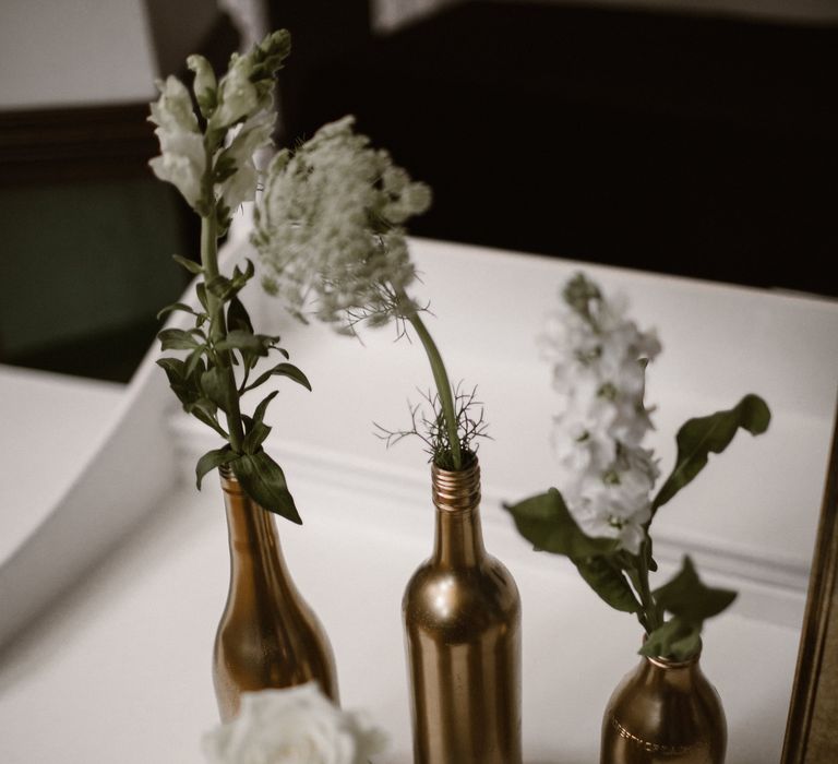 Gold Spray Painted Bottles filled with White Flower Stems