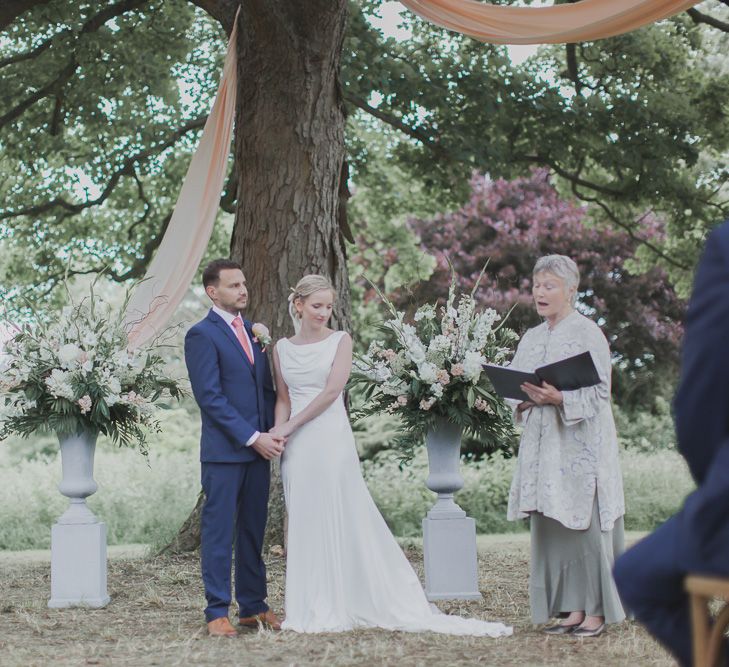 Wedding Ceremony | Bride in Justin Alexander Gown | Groom in Moss Bros Suit | Outdoor Peach Wedding at Courteenhall House in Northamptonshire Planned by Your Story Events | Ferri Photography