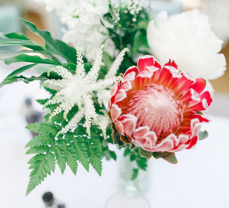 Protea Flower Stems in Bottles | Secret Garden Reception at Castle Cottage Cafe, Oakham | White Stag Wedding Photography