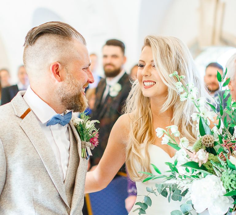 Wedding Ceremony at Normanton Church on Rutland Water | Pronovias Wedding Dress | Groom in Cream Herringbone Tweed Suit from Marc Darcy | White Stag Wedding Photography