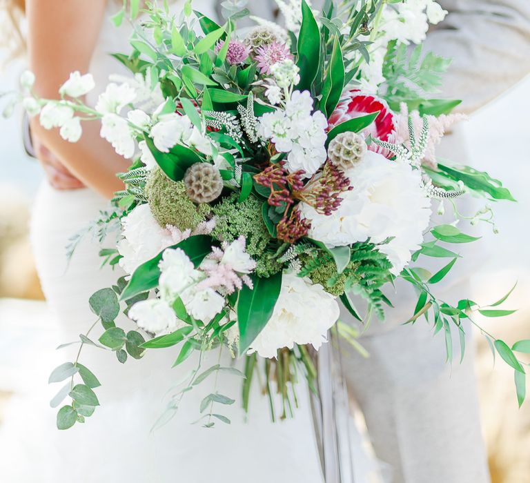 Oversized Bridal Bouquet | Bride in Pronovias Wedding Dress | Groom in Cream Herringbone Tweed Suit from Marc Darcy | Normanton Church on Rutland Water | White Stag Wedding Photography