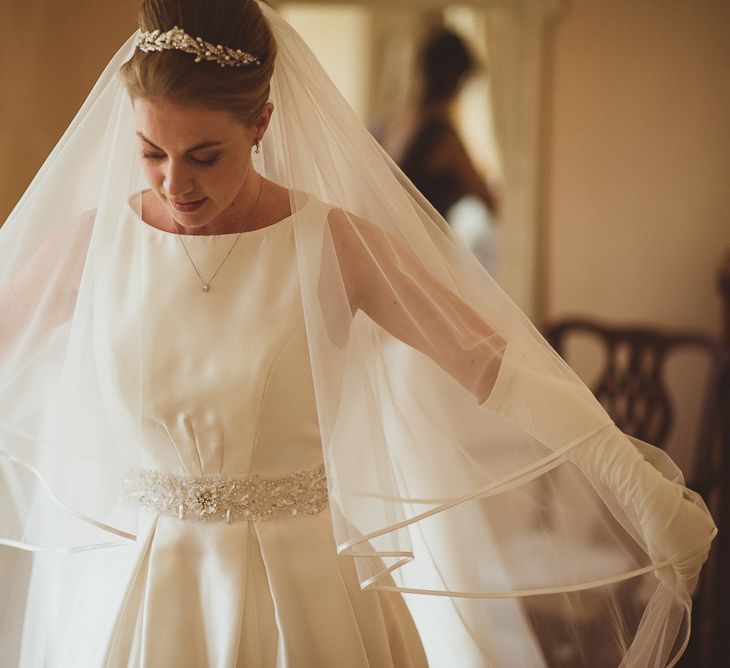 Bride in Tom Flowers Dress, Long Satin Gloves & Ivory & Co. Headdress Getting Ready