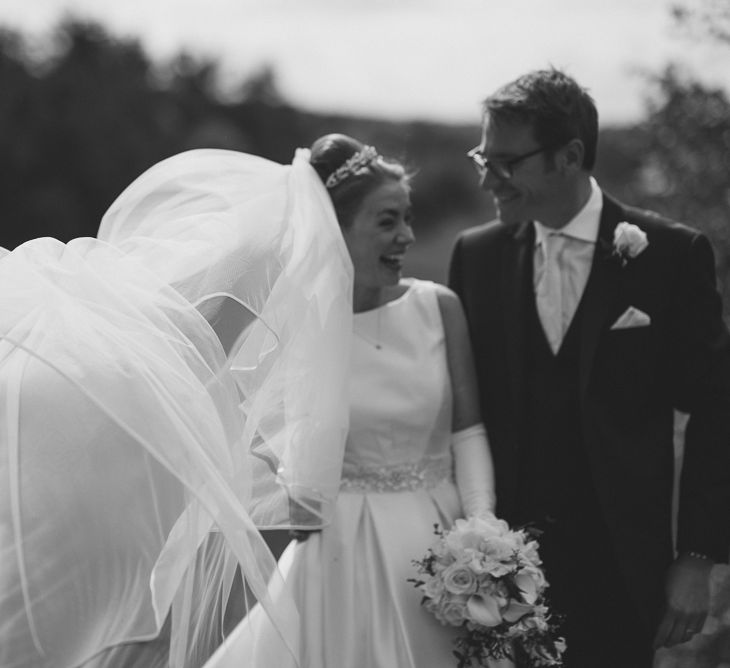 Bride in Tom Flowers Dress, Long Satin Gloves & Ivory & Co. Headdress and Groom in Moss Bros Suit