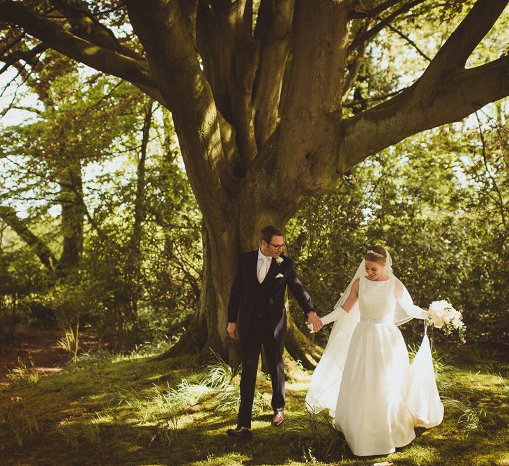 Bride in Tom Flowers Dress, Long Satin Gloves & Ivory & Co. Headdress and Groom in Moss Bros Suit