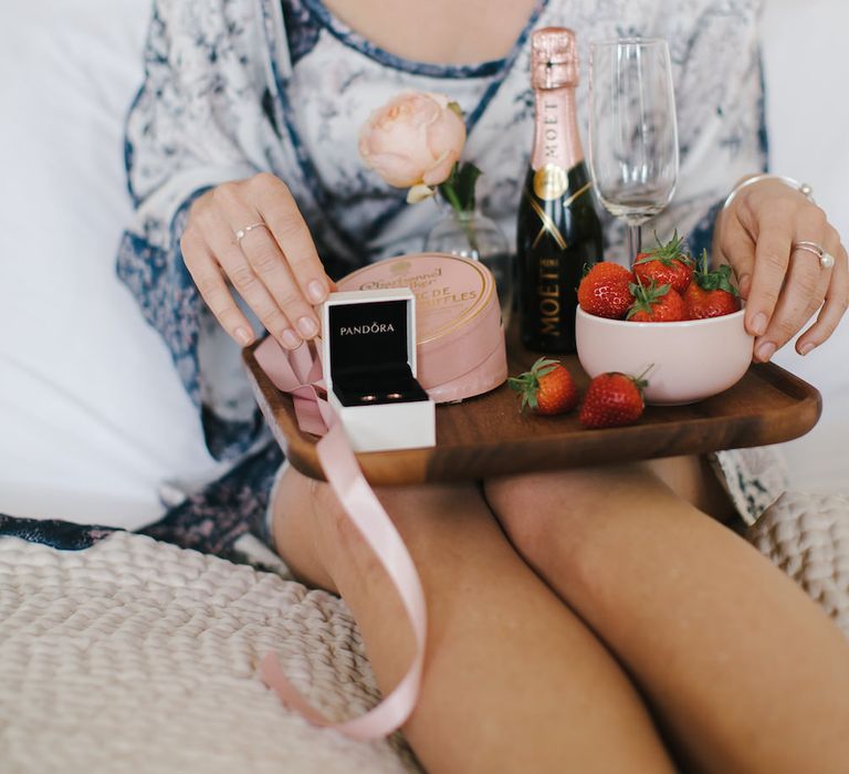 Bridesmaid in floral chemise and breakfast tray with PANDORA rose gold earrings