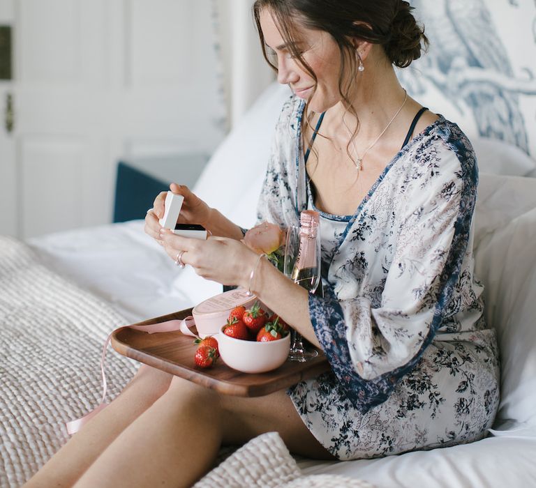 Bridesmaid in floral chemise and breakfast tray with PANDORA rose gold earrings