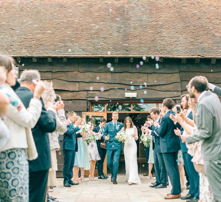 Confetti Exit | Bride in Fred & Ginger Bridal Design Gown | Groom in Navy Mullen Mullen Suit | Pastel Spring Wedding at Loseley Park Barn | Sarah-Jane Ethan Photography | Captured Media Weddings Film