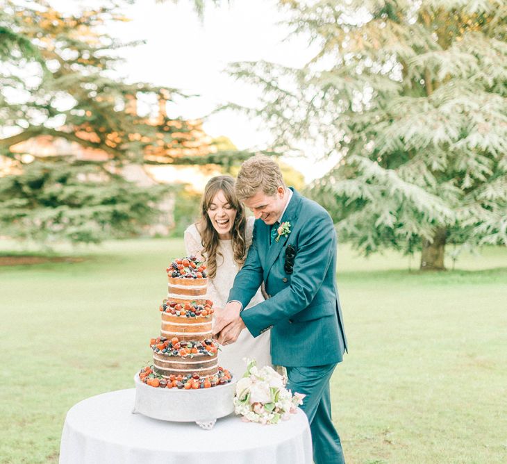 Cutting The Cake | Bride in Fred & Ginger Bridal Design Gown | Groom in Navy Mullen & Mullen Suit | Pastel Spring Wedding at Loseley Park Barn | Sarah-Jane Ethan Photography | Captured Media Weddings Film