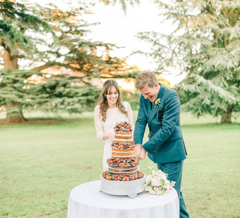 Cutting The Cake | Bride in Fred & Ginger Bridal Design Gown | Groom in Navy Mullen & Mullen Suit | Pastel Spring Wedding at Loseley Park Barn | Sarah-Jane Ethan Photography | Captured Media Weddings Film