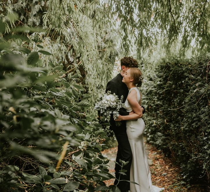 Bride In Sarah Seven Dress & Groom In All Black With Bridesmaids In White Shift Dresses And Foliage Decor With Images By Nataly J Photography