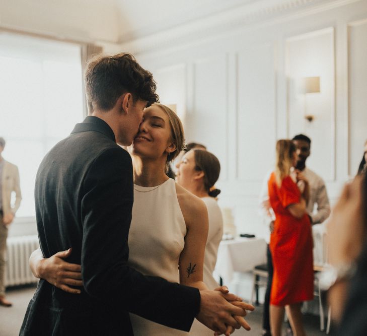 Bride In Sarah Seven Dress & Groom In All Black With Bridesmaids In White Shift Dresses And Foliage Decor With Images By Nataly J Photography