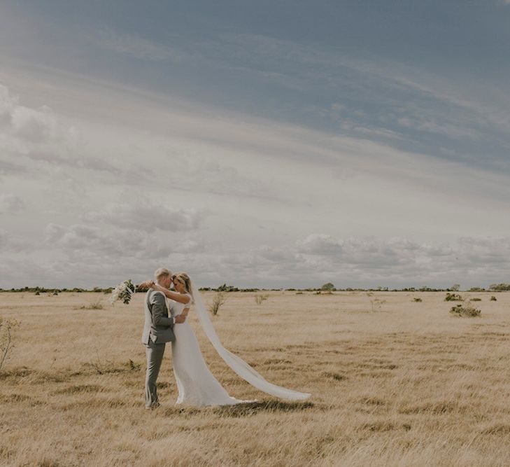 Bride in By Malina Bridal Gown & Groom in Grey Tiger of Sweden Suit