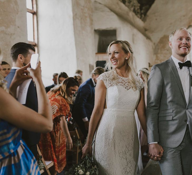 Bride in By Malina Bridal Gown & Groom in Grey Tiger of Sweden Suit