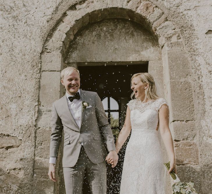 Bride in By Malina Bridal Gown & Groom in Grey Tiger of Sweden Suit