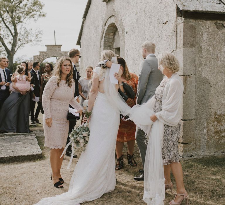 Bride hugging Wedding Guests outside the Church