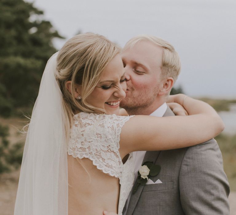 Bride in By Malina Bridal Gown & Groom in Grey Tiger of Sweden Suit