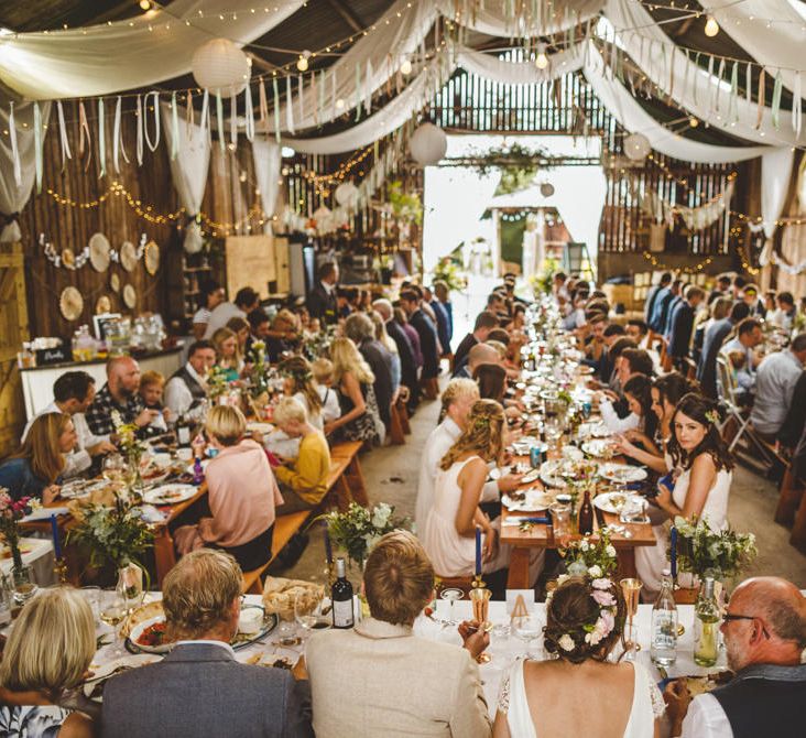 Wooden Trestle Tables With Bud Vases And White Drapes // Daisy By Halfpenny London For A Boho Barn Wedding In Yorkshire With Decor By Wild At Heart Weddings Images By Photography 34