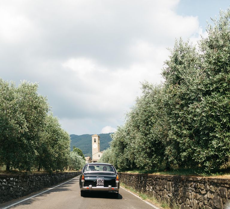 Vintage Wedding Car driving off in the Italian Sunset