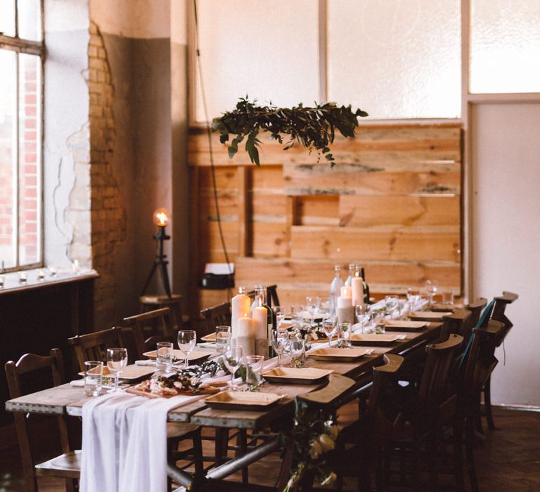 Rustic Trestle Table with Hanging Greenery Decor | The Harbour Church Portsmouth Wedding | Emily & Steve Photography