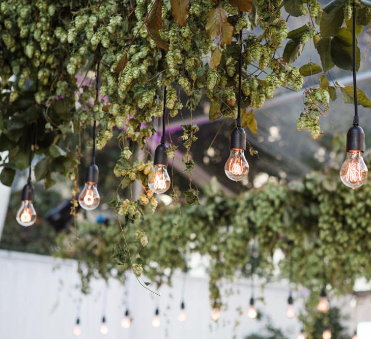 Botanical Marquee Reception with Hanging Greenery & Edison Light Installations | Lucy Davenport Photography