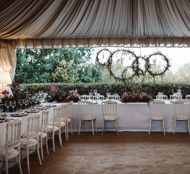 Reception Decor | Greenery Hoops Top Table Backdrop | Tropical Green & Fuchsia Pink Outdoor Wedding at Castellina de Miremont, Italy Planned & Styled by Come le Ciliegie Wedding & Events | Images by Effeanfotografie | Film by Headshot Weddings