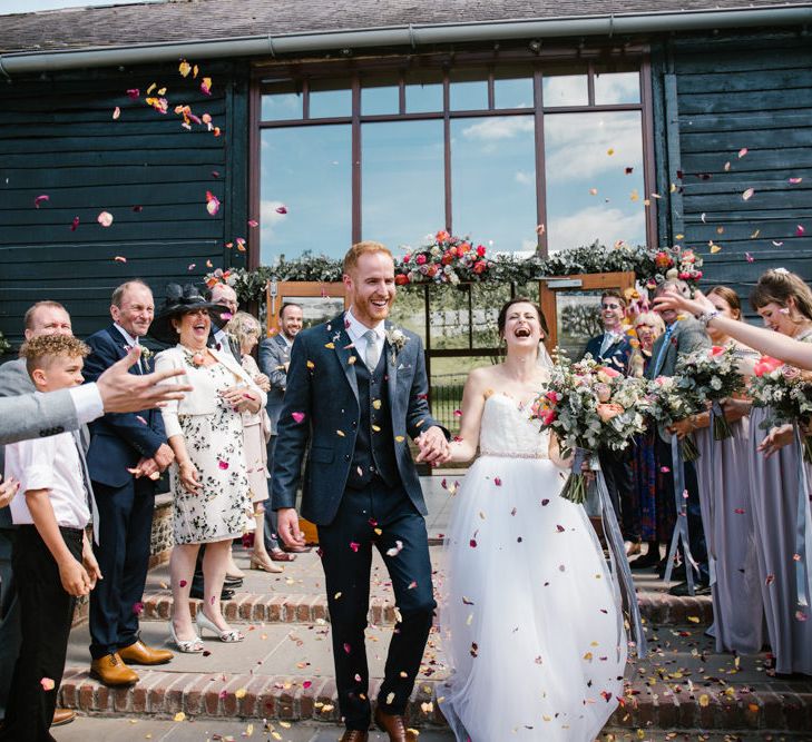 Confetti Exit | Bride in Sarah Seven Gown | Groom in Ted Baker & Next | DIY Wedding at Upwaltham Barns with Bright Flowers | Danielle Victoria Photography