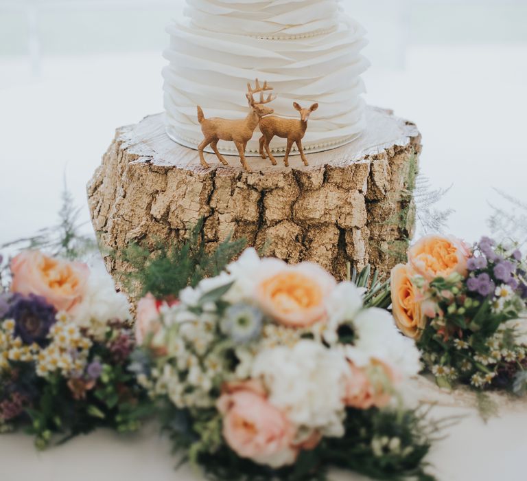 White Buttercream Wedding Cake On Log Slice