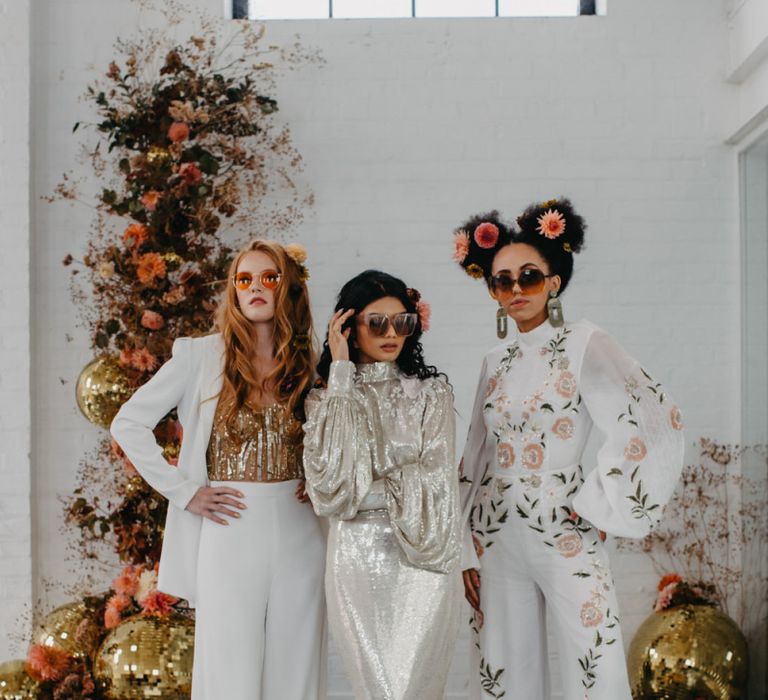 Stylish brides in sequin dress, embroidered jumpsuit and wedding trousers for 70s disco wedding inspiration