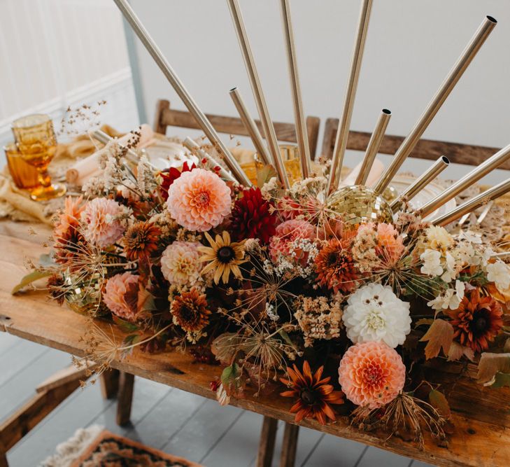 Floral centrepiece wedding decor with dahlias for 70s disco wedding theme