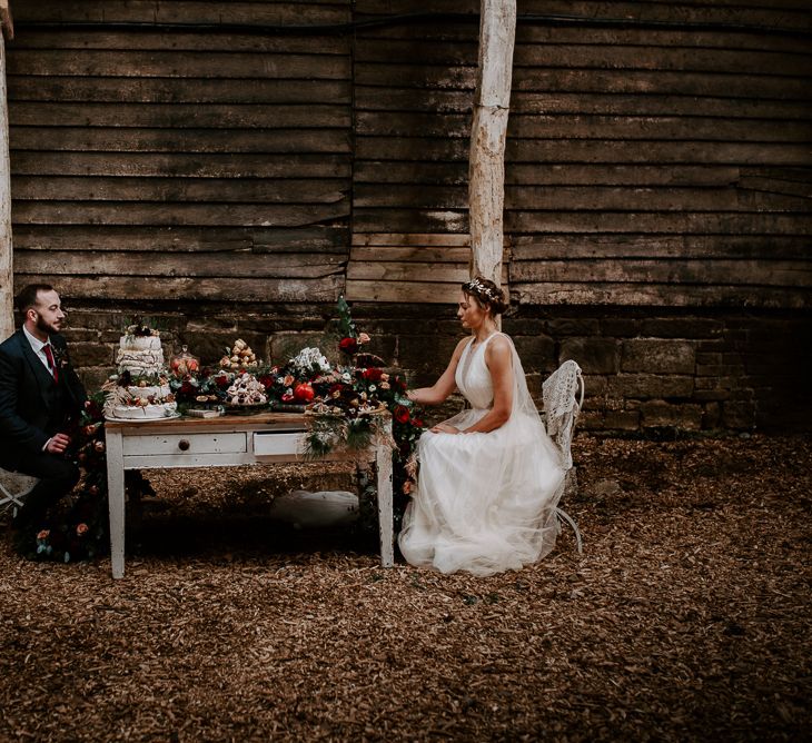 Bohemian Bride and Groom Eating Dessert from their Cake Table