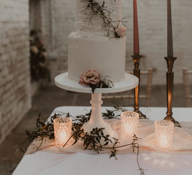 Two Tier Frosted Wedding Cake with Flower Decor &amp; Taper Candles | Romantic Pink and Gold Wedding Inspiration in a Modern Summer House at Garthmyl Hall by KnockKnockPenny Studio | Nesta Lloyd Photography