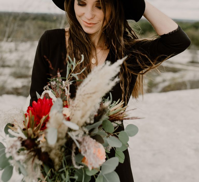 Bride in Portez Vos Idées Black Wedding Dress | Pampas Grass, Eucalyptus &amp; Red Rose Wedding Bouquet | Wild Same Sex Couple Wedding Inspiration Shoot | Anne Letournel Photography